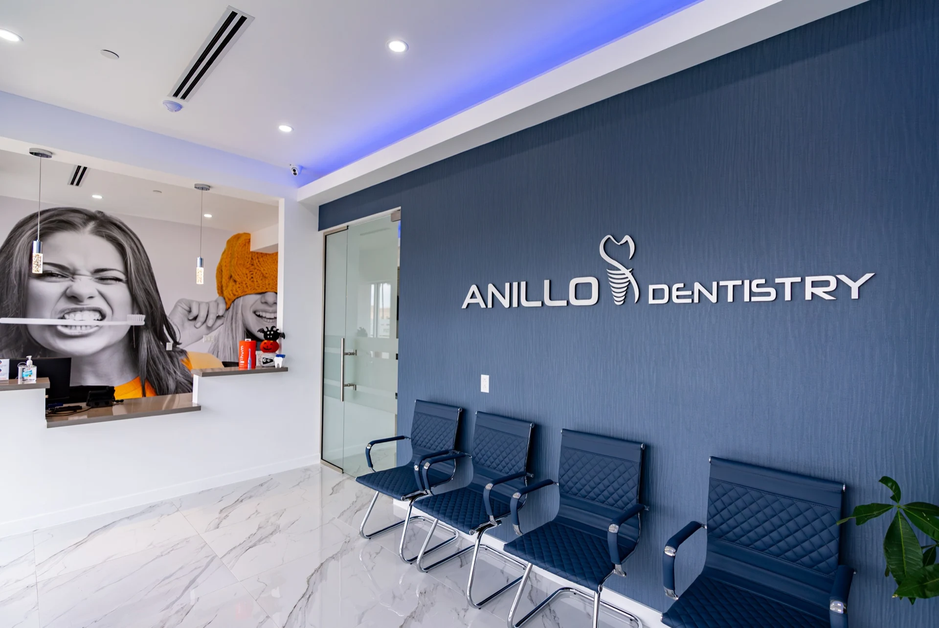 Anillo Dentistry — Waiting room with ANILLO DENTISTRY lettering on a navy wall and rows of navy chairs