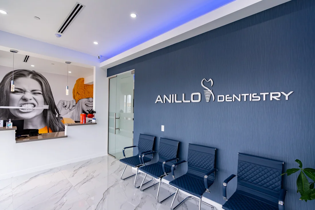 Anillo Dentistry — Waiting room with ANILLO DENTISTRY lettering on a navy wall and rows of navy chairs