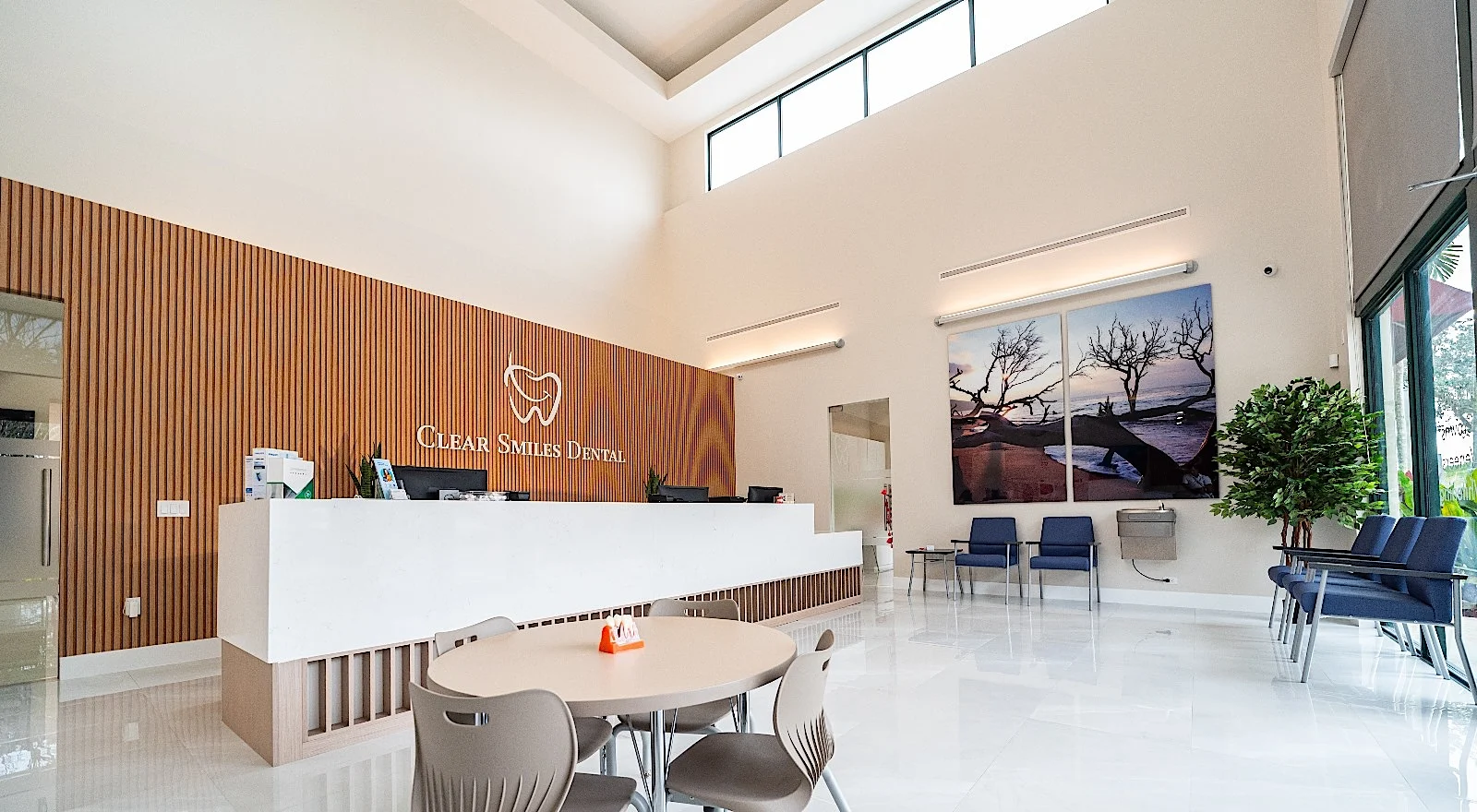 Clear Smiles Dental — Wide view of reception with a round table, the slatted wall and clerestory windows
