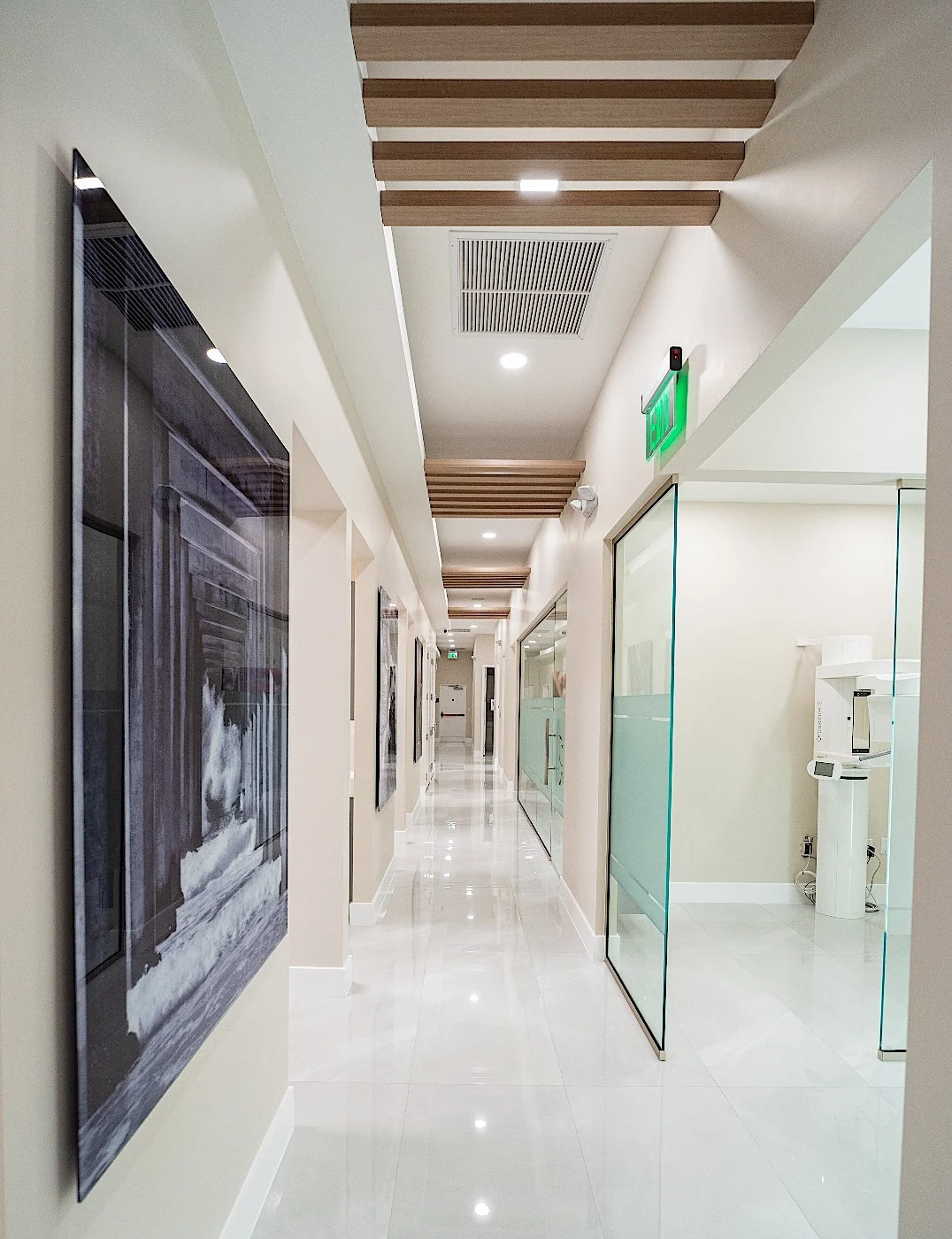 Clear Smiles Dental — Long corridor with a black-and-white panel, glass partitions and timber beams overhead