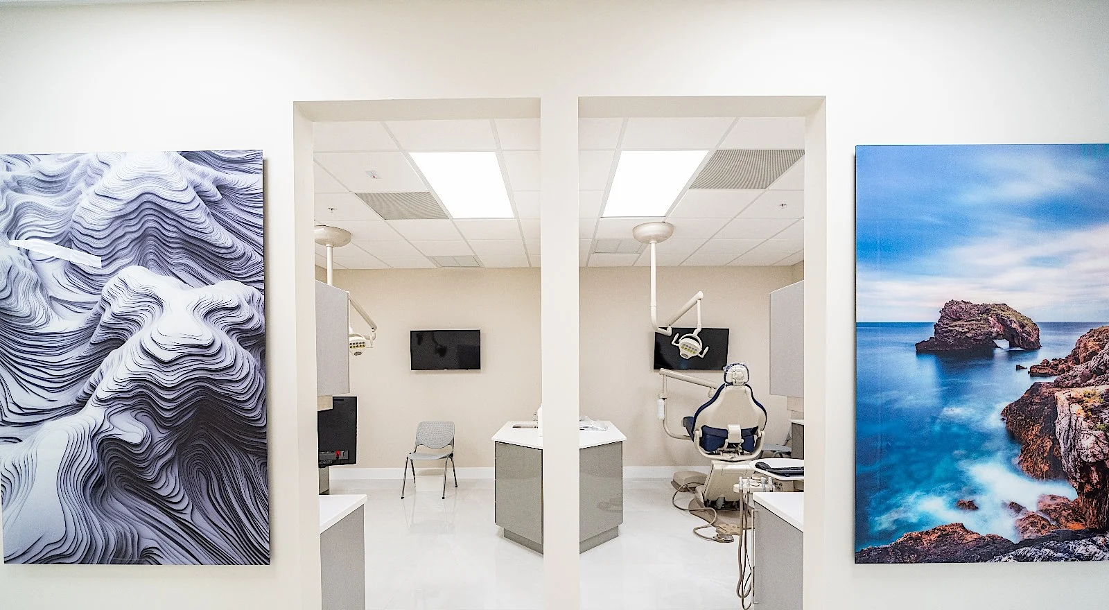 Clear Smiles Dental — Doorways into two treatment rooms, between a white wave relief and a coastal photograph