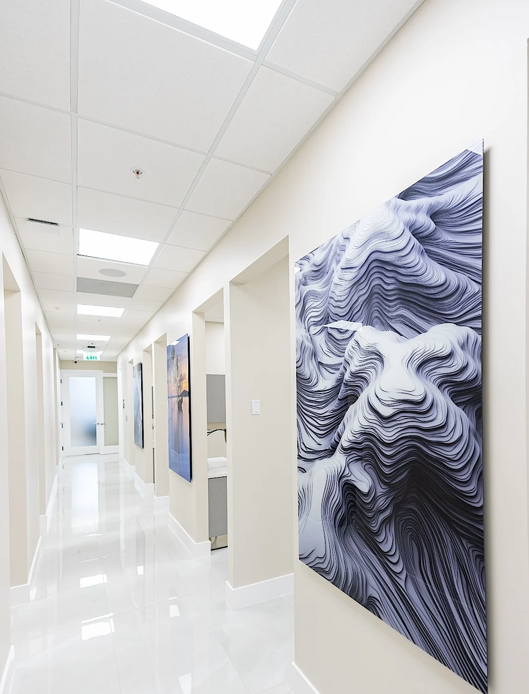 Clear Smiles Dental — Corridor with a large white sculptural relief over a glossy porcelain floor