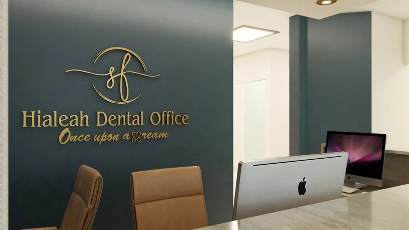 Hialeah Dental Office — Reception desk and leather chairs before a dark teal wall with the gold logo and the tagline “Once upon a dream”