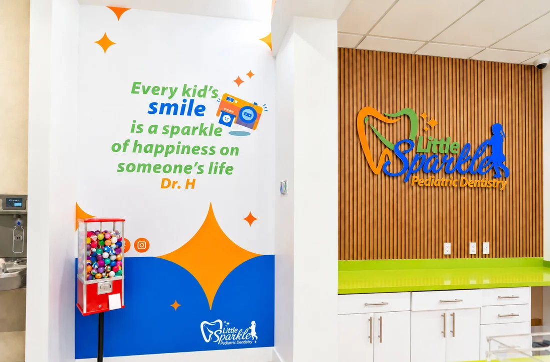 Little Sparkle Pediatric Dentistry — Reception wall with a quote in green and blue lettering over a large orange star, beside a dimensional logo on timber slats