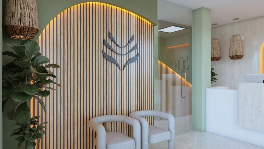 Nüe Dental Clinic — Waiting corner with two gray armchairs before an arched, backlit wood-slat wall with a leaf-like emblem