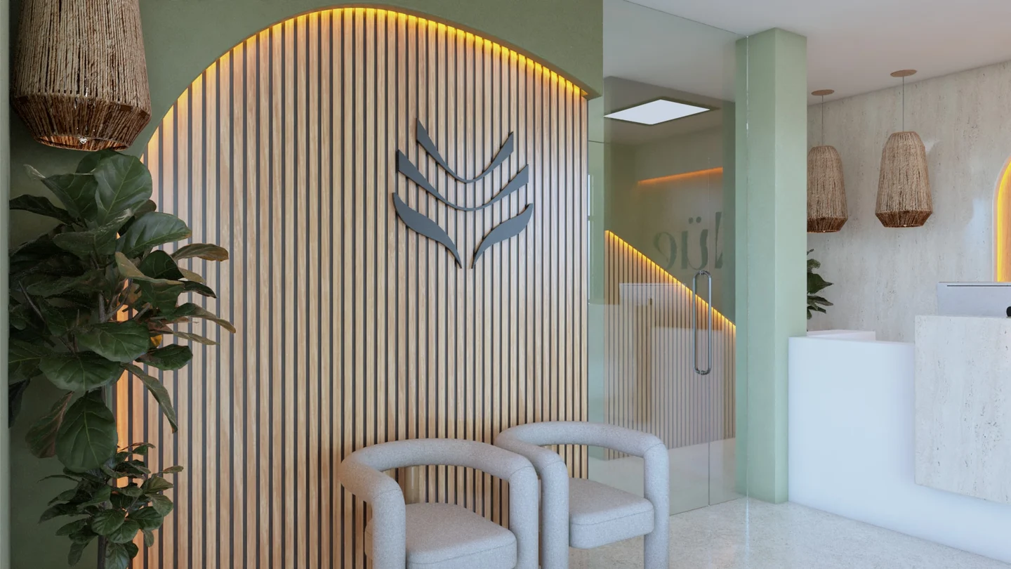Nüe Dental Clinic — Waiting corner with two gray armchairs before an arched, backlit wood-slat wall with a leaf-like emblem