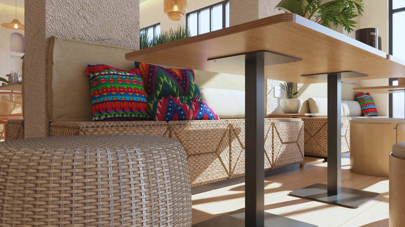 Pupusería Delicias de Maíz — Close-up of a woven banquette with brightly patterned cushions beside a wood table on a black base