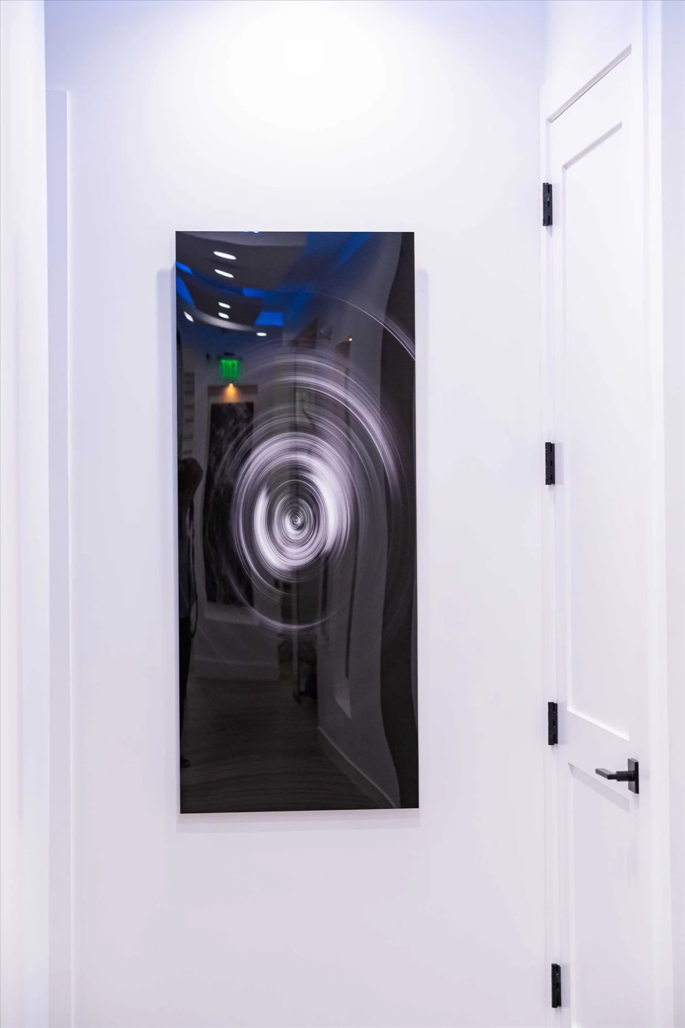Select Dental Care — Black-and-white spiral panel on a white wall beside a door