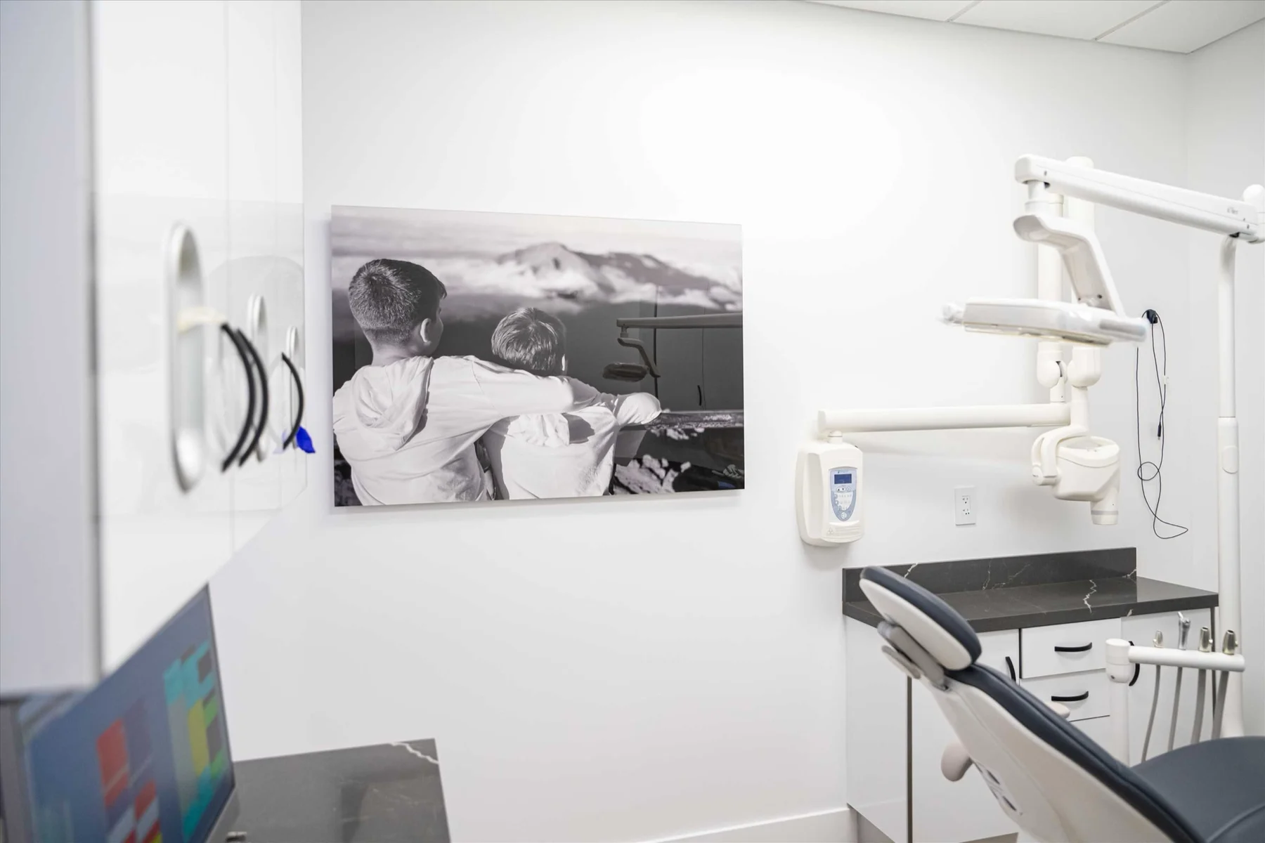 Select Dental Care — Treatment room with a black-and-white photograph of two children looking out at mountains