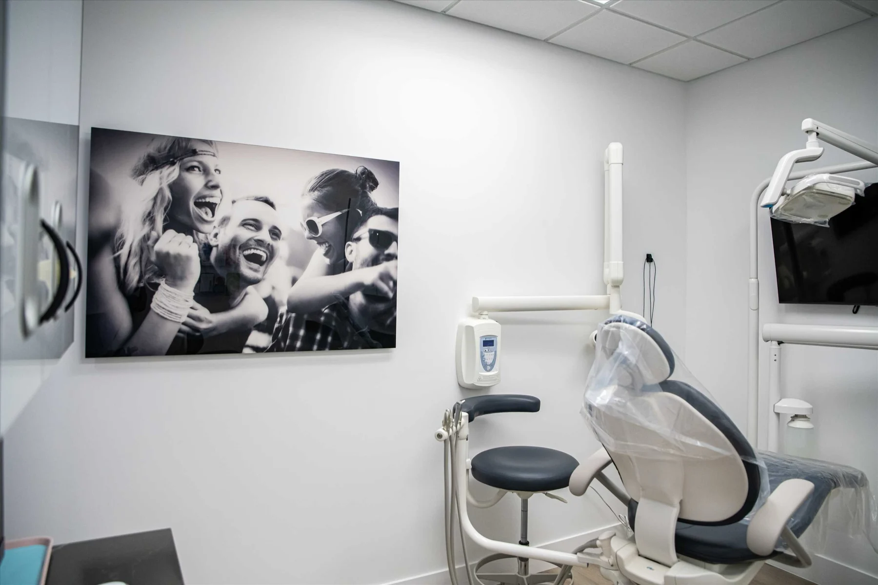 Select Dental Care — Treatment room with a black-and-white photograph of friends laughing, beside the dental chair