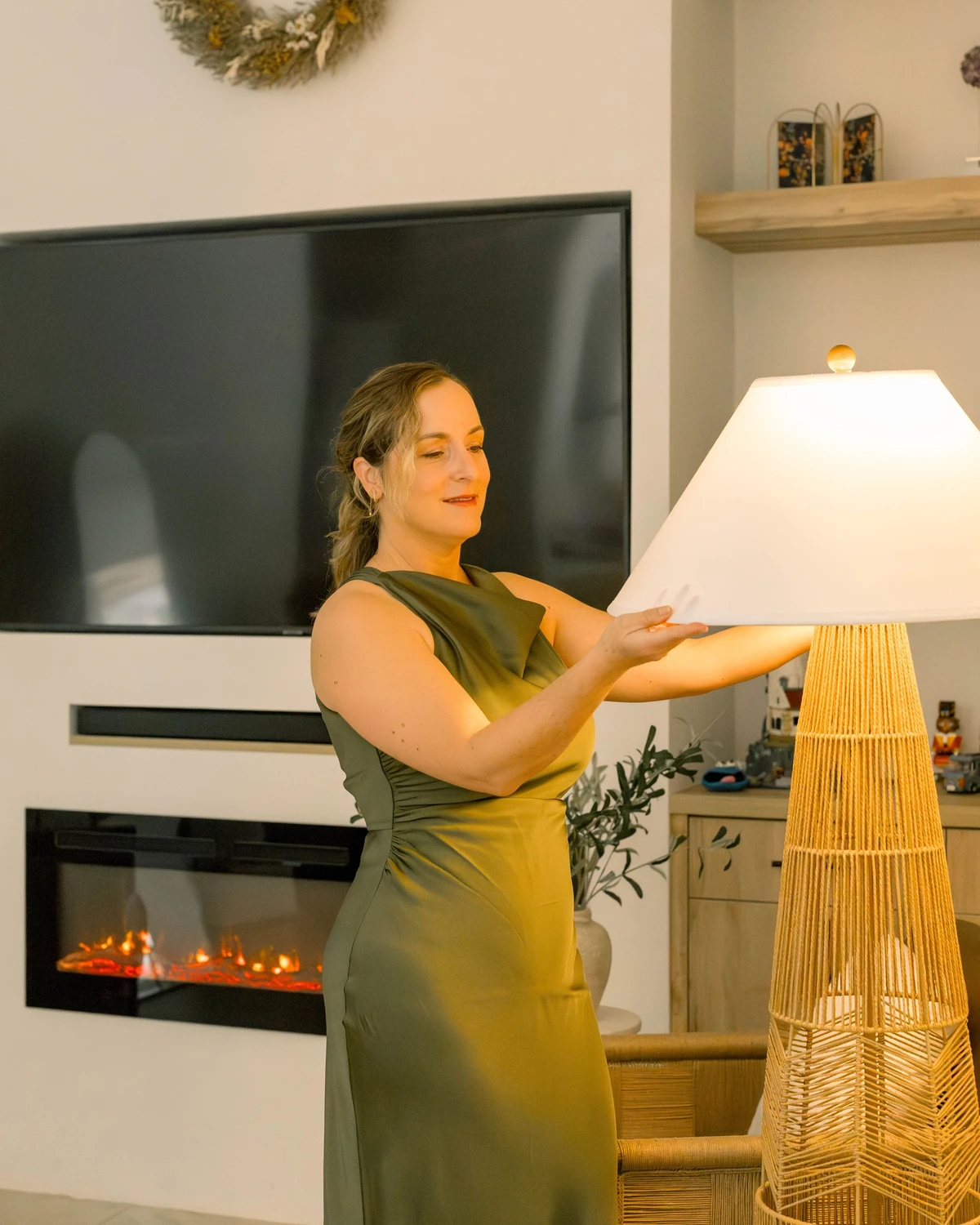 Yai Gómez, founder of Nature Violet Art, adjusting a floor lamp in a finished living room